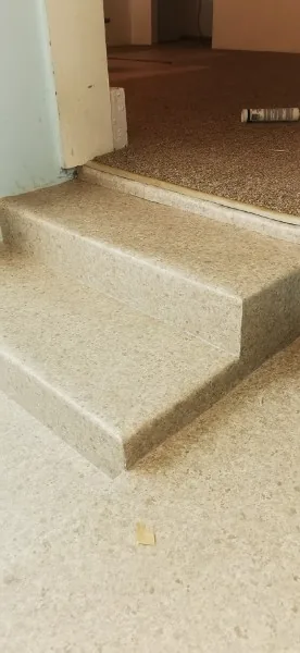 Sheet vinyl taken up and over a step in a Mission home
