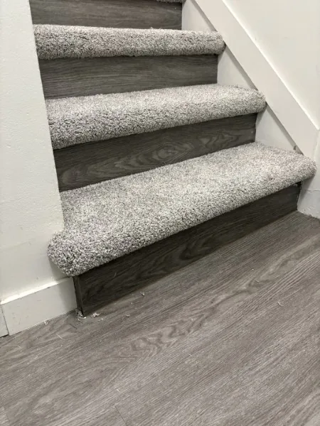 The bottom step of a Mission staircase, carpet wrapped round the nose