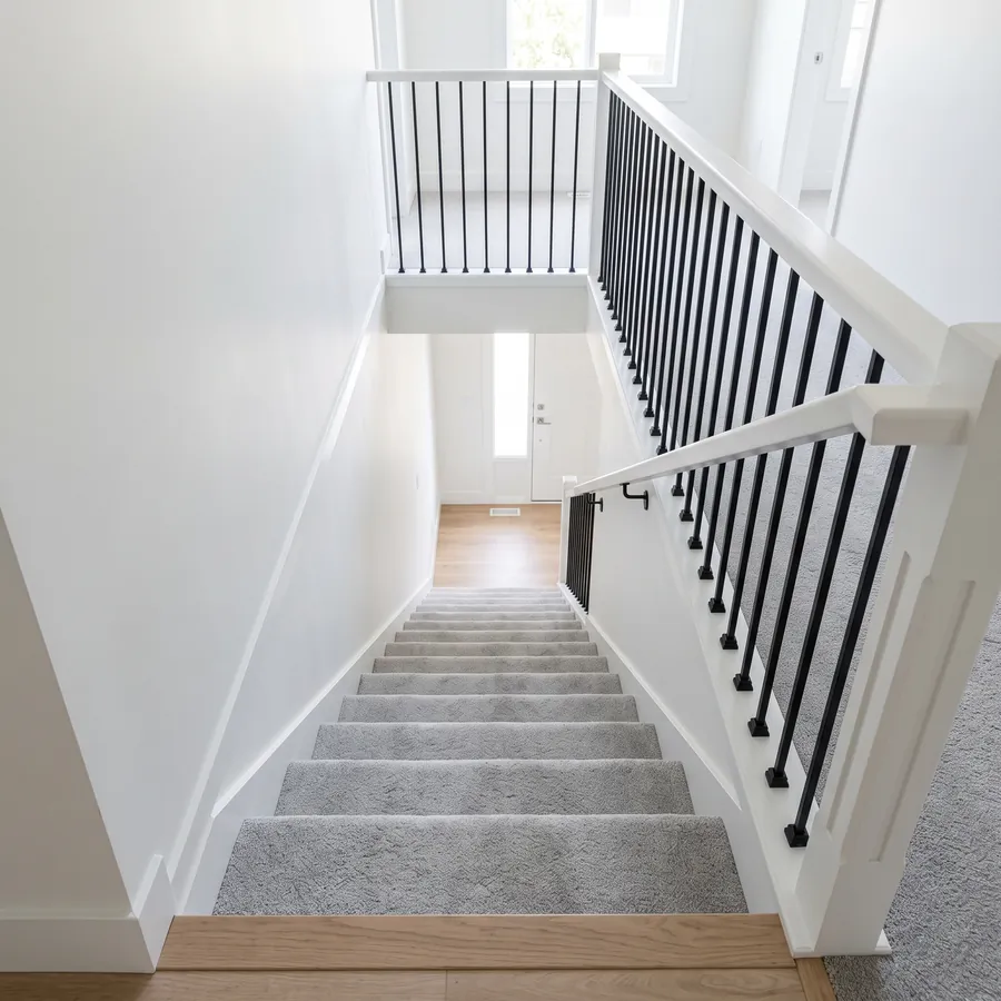 Looking down a carpeted staircase from the top landing